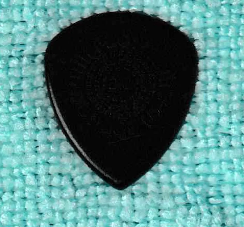 A dark Example of a Dunlop made Jazz III Shaped pick, larger size.