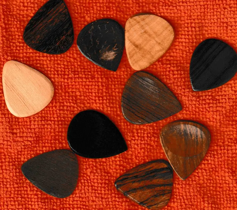 A small assortment of some of my wooden guitar picks against a red background, more coming...