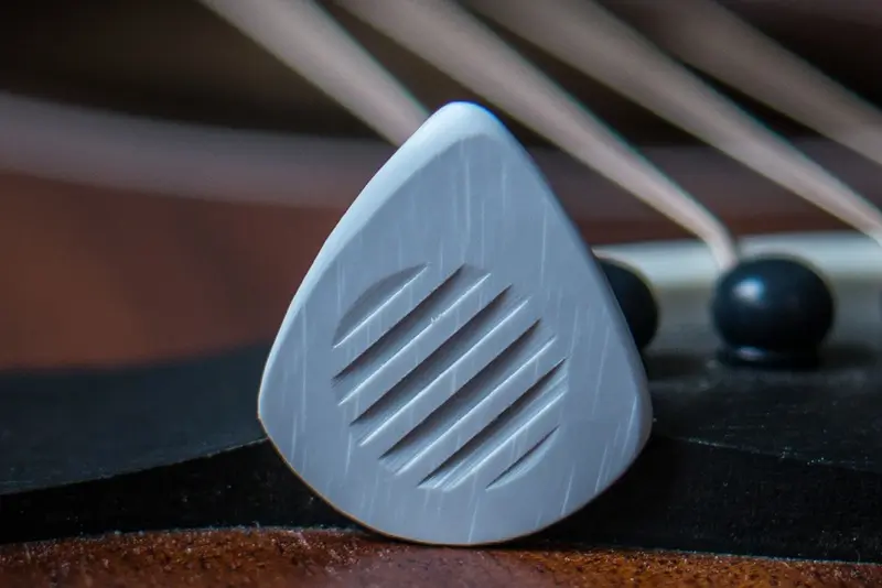 A Special Well Crafted Wedge Pick with Grip lines, in gray, with Speed Bevels on the playing edges.