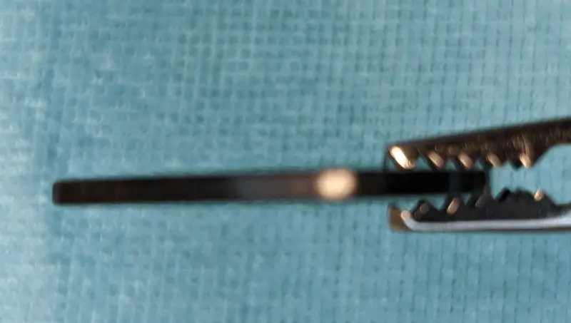 A blurry Edge-On view of the Ebonya Coelacanth Extra Heavy 2.0mm Pick against blue background. Note the hard square edging.