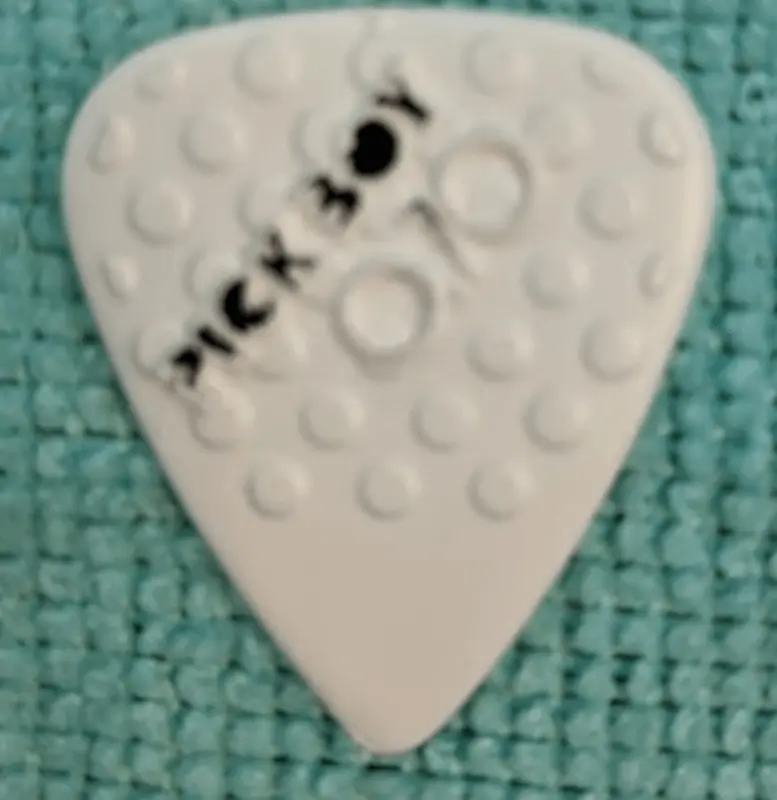 The Japanese Pick Boy Branded Ceramic and nylon coated plectrum. 0.70mm model in white against a blue backrop.