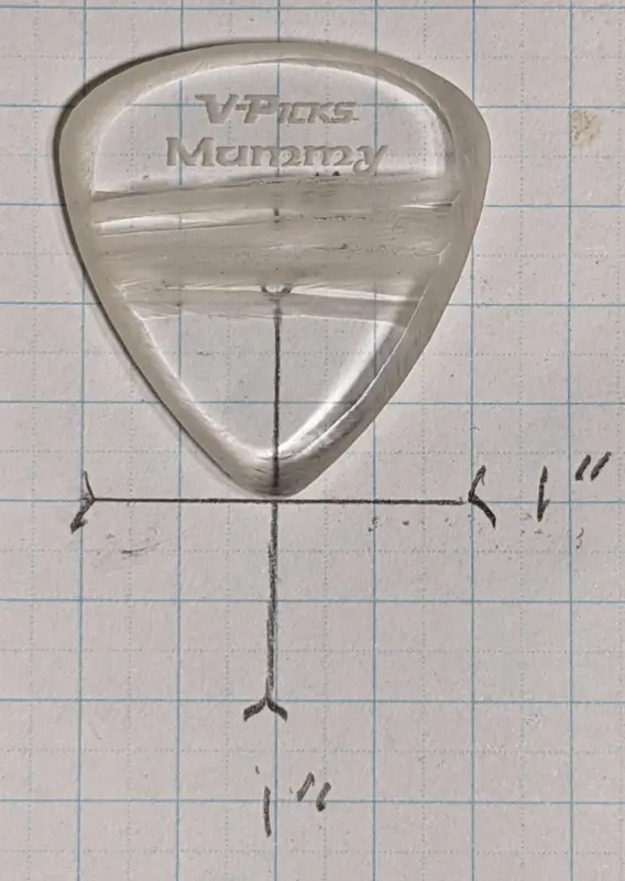 The Mummy pick by V-Picks set against 1/4" ruled Graph Paper for size reference. Note how clear the pick is.
