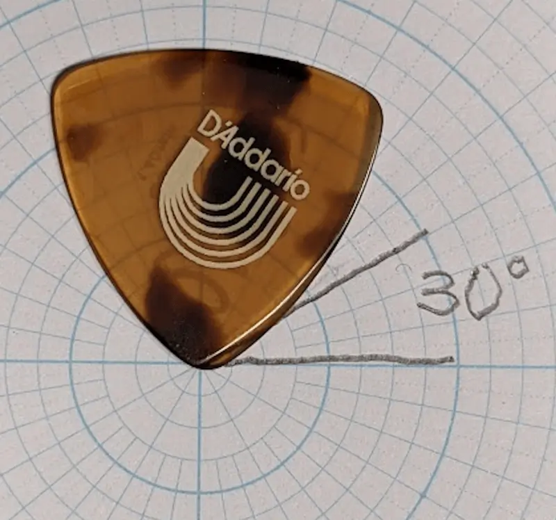 The Chris Thile Signature pick of Casein against circular and angle ruled paper for angle reference. Note Speed beveling at tip