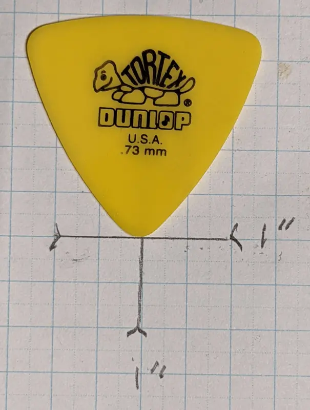 Jim Dunlop's Yellow Reauleaux Tortex Material pick against 1/4" ruled graph paper for size reference.