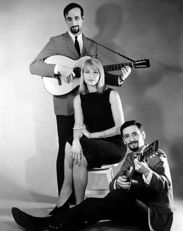 A black and white image of Peter Paul and Mary posing for the camera