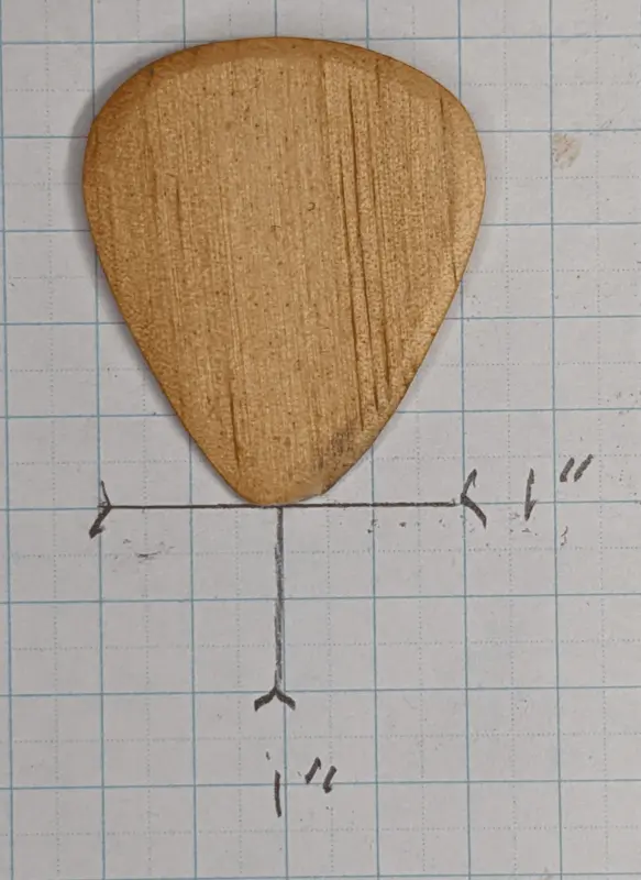 The Pine Wood Pick by Iskra Woodcrafts against 1/4" ruled graph paper for size reference. Note tip wear from about 10 hours play time.