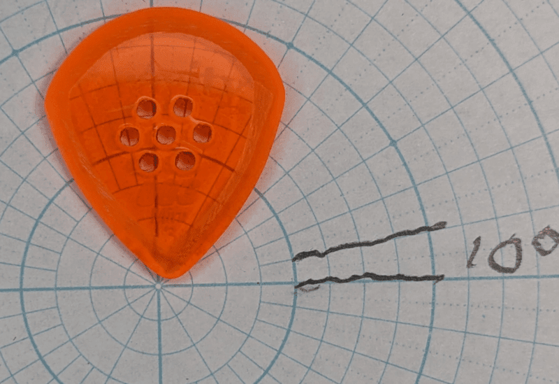 The Gravity Picks Brand JazzIII model 003 in Neon Orange on Angle Paper