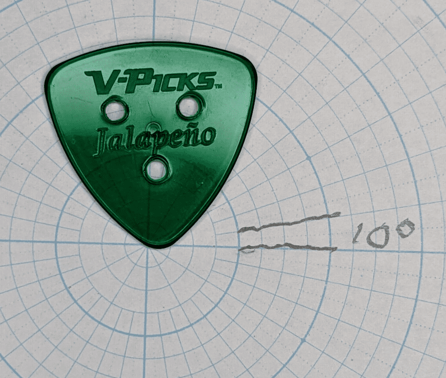 The V-Picks Jalapeno Brand 3 hole Guitar Pick over Angle Graph Paper for angle reference.