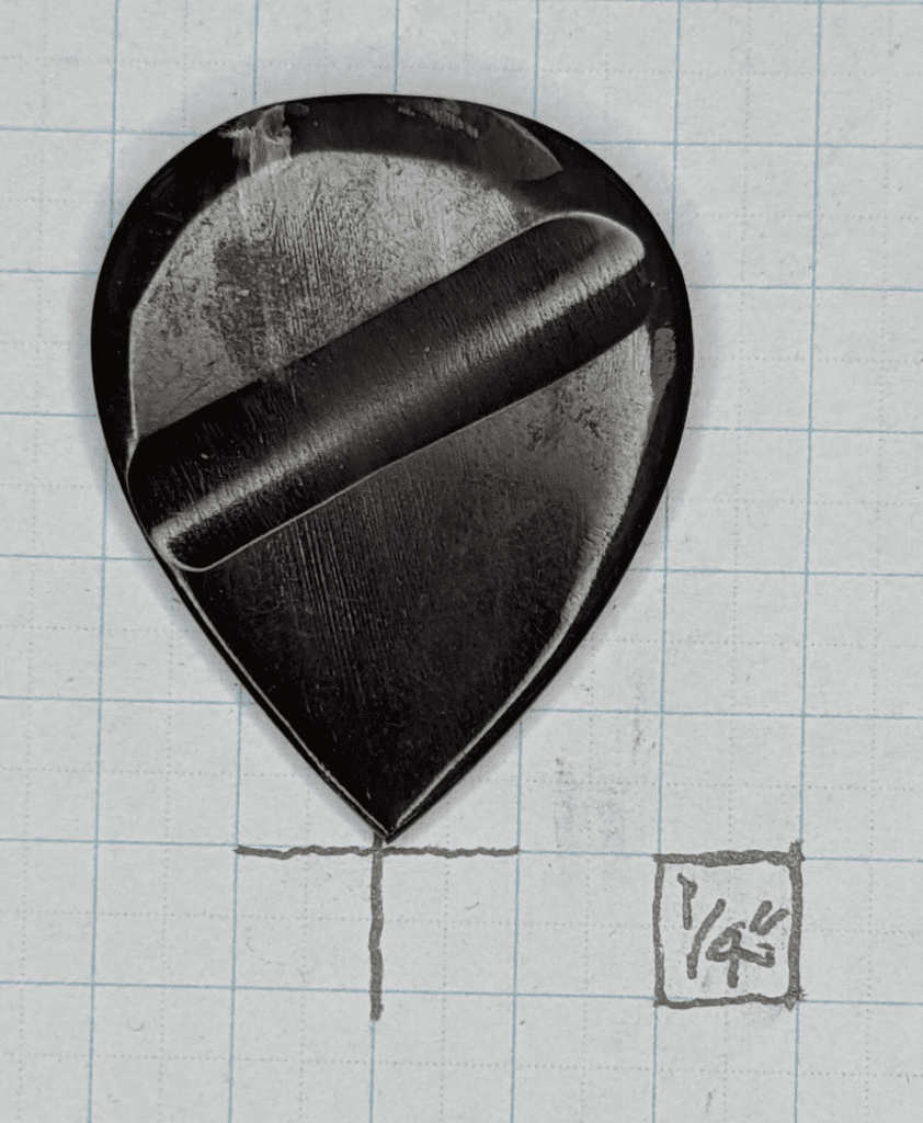 The Guitar Heads Black Buffalo Horn pick shown against 1/4" Graph Paper for Reference.