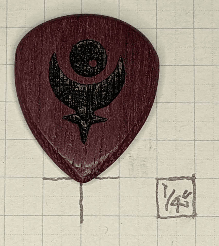 The lovely and deeply colored Purple Heart Pick against 1/4" block graph paper for reference.
