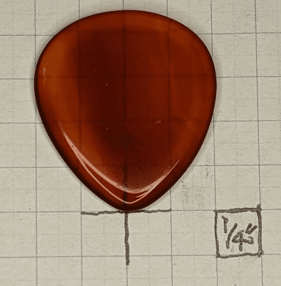 Red Agate Pick on top of 1/4" Box Graph Paper for size reference
