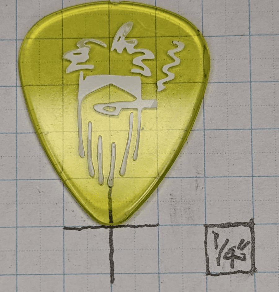 The Dunlop Brand Reverend Willy's bright yellow guitar pick against a 1/4" ruled graph paper backdrop.