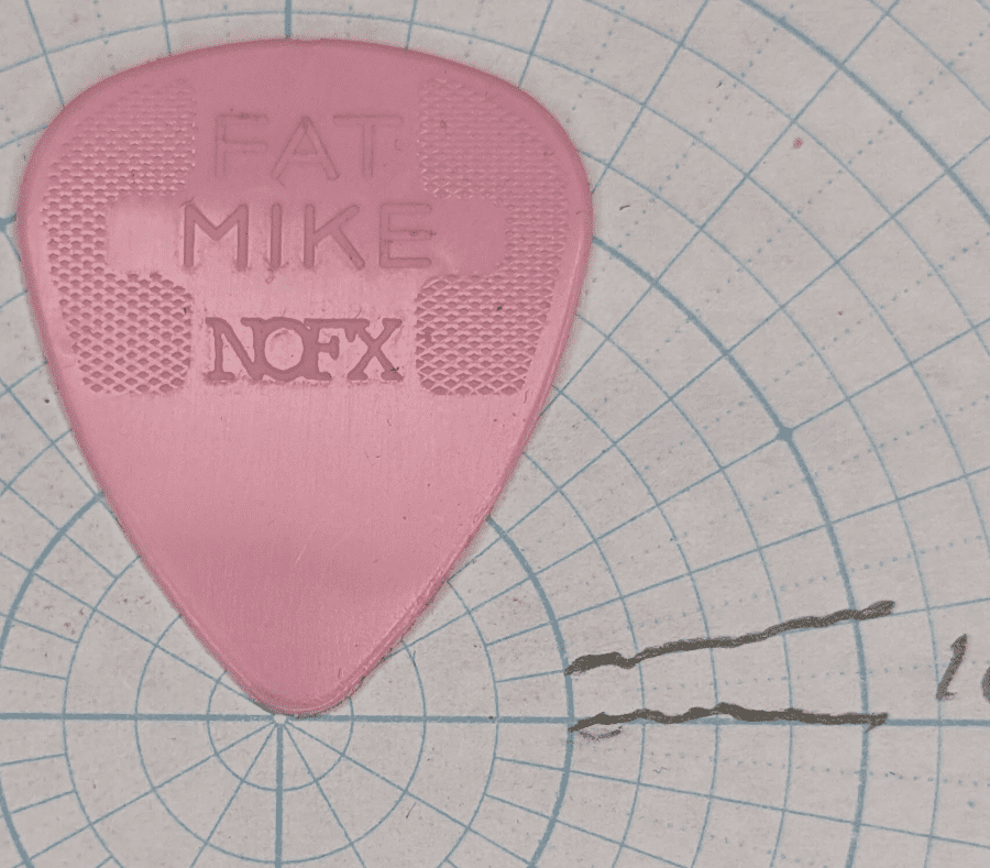 The Pink Jim Dunlop Manufacturer's Fat Mike Pick Against 10 Degree Circular Angled Paper for shape reference.