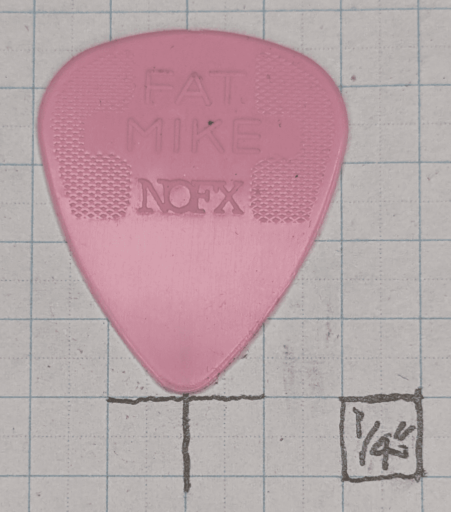 Fat Mike's Signature Guitar Pick Against 1/4" Ruled Graph Paper for Size Reference.