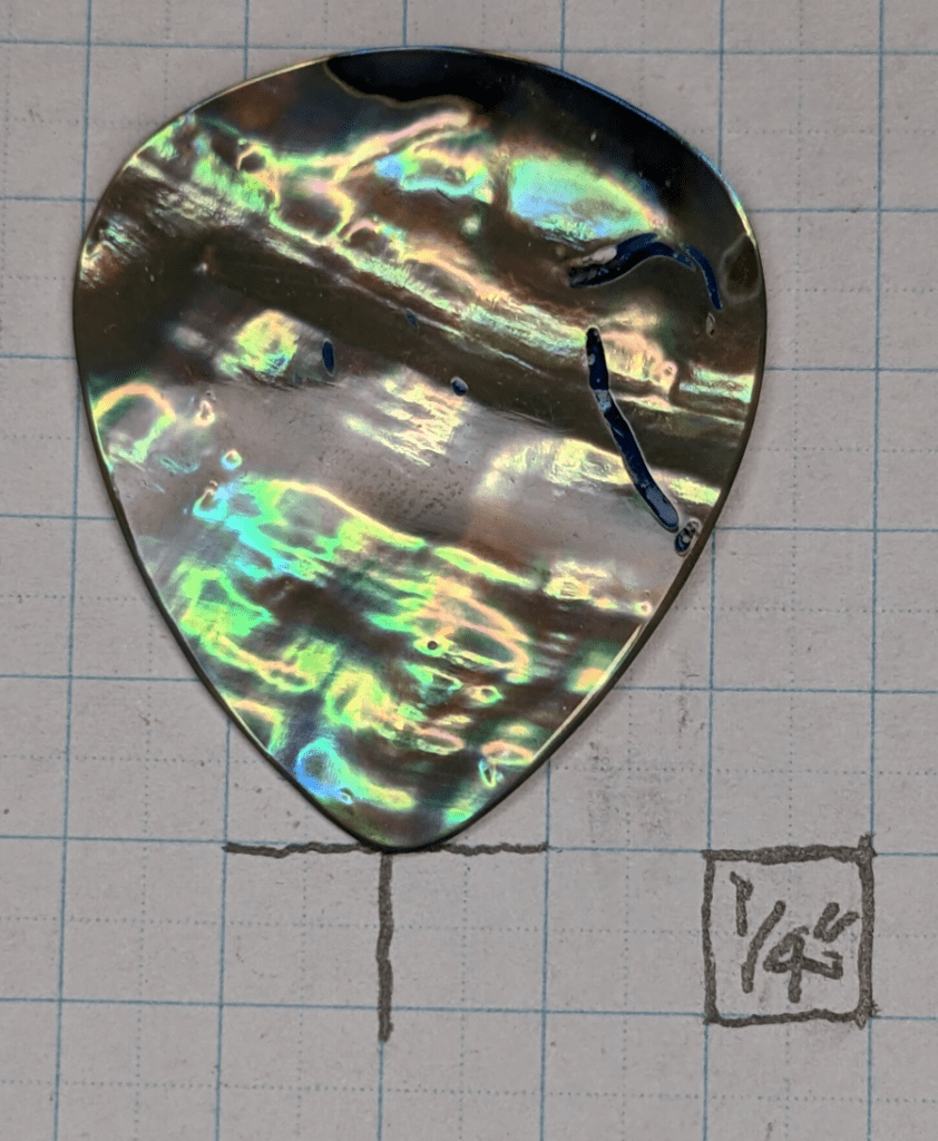 Newport ScrimShanders handmade Plectrum set on 1/4" ruled Graph Paper for size reference, viewing obverse side.