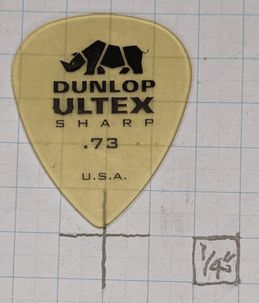 Jim Dunlop Ultex Sharp .73 Size on Graph Paper for size reference, note the clear yellow color of the Ultem material