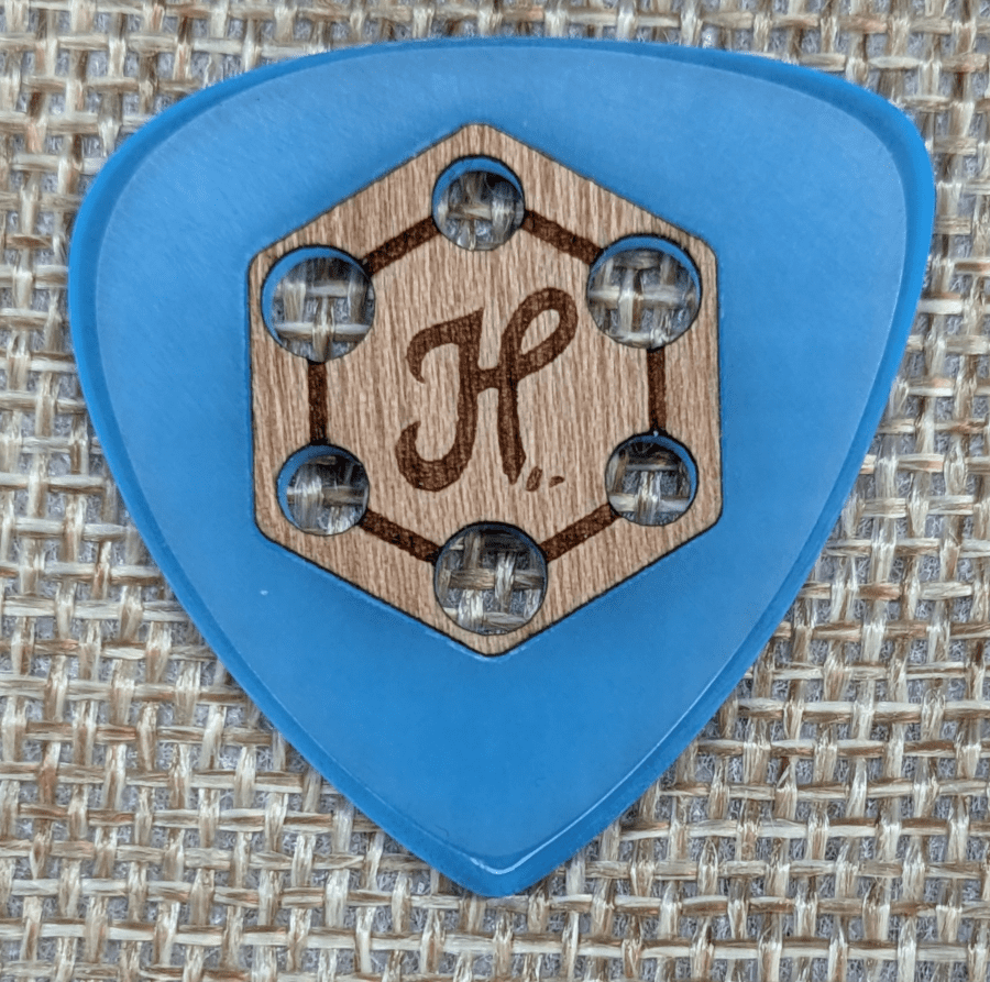 Honey Picks Wood Grip Glow Cast Tri Tip Set Against Burlap Backing, A Triple Tip Threat Guitar Pick of Acrylic and Wood
