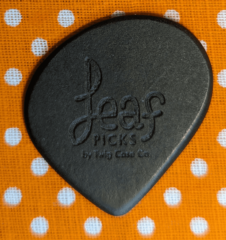 The leaf pick by Twig Case Company. A paper pick using a material known as Richlite used for many things such as guitars. Polka Dot background.